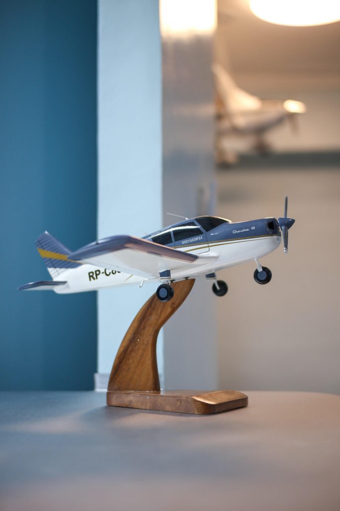 Single engine aircraft piper cherokee 140 model plane made of wood placed on a table